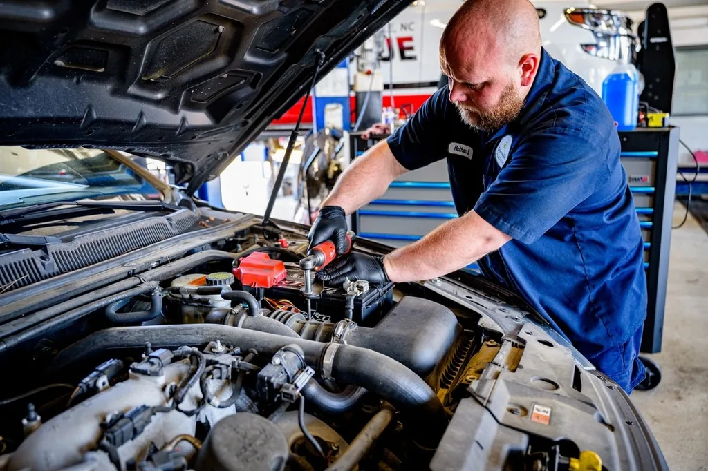 A mechanic under the hood of a truck