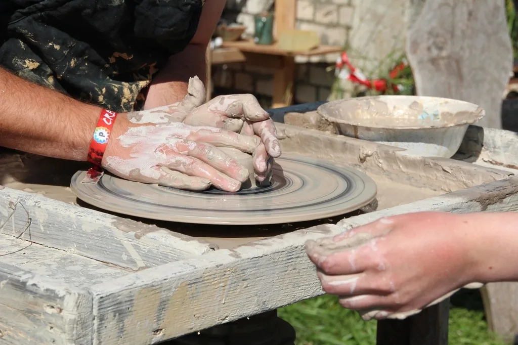 Hands centring clay on a potter's wheel
